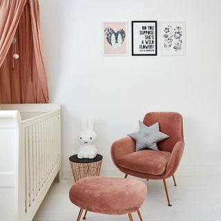 White walls and floor with white cot, pink canopy tent, pink armchair and footstool with cuddly toy