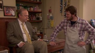 Chris Pratt as Andy Dwyer at his shoeshine stand talking to Kyle