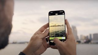 A person holds an iPhone with the VSCO Capture app