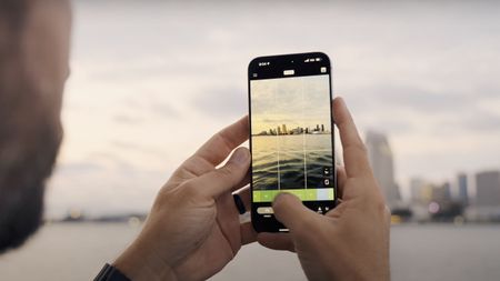 A person holds an iPhone with the VSCO Capture app