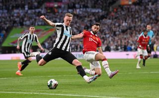 Newcastle player Sean Longstaff shoots despite the challenge of Bruno Fernandes during the Carabao Cup Final match between Manchester United and Newcastle United at Wembley Stadium on February 26, 2023 in London, England. 