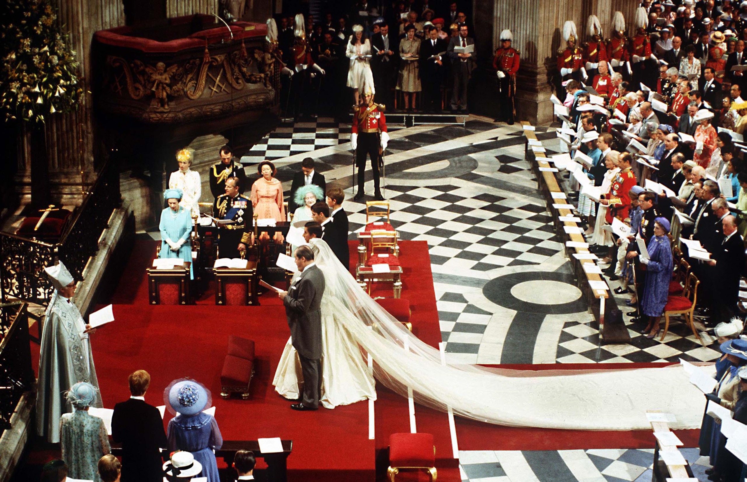 Princess Diana and Prince Charles standing at the altar on their wedding day surrounded by members of the Royal Family and Spencers