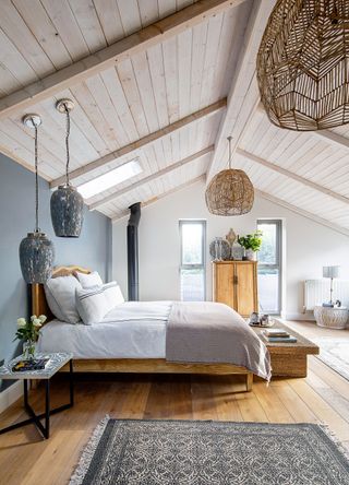 double bedroom with pale blue gray walls and high ceiling with picture window rattan lampshade