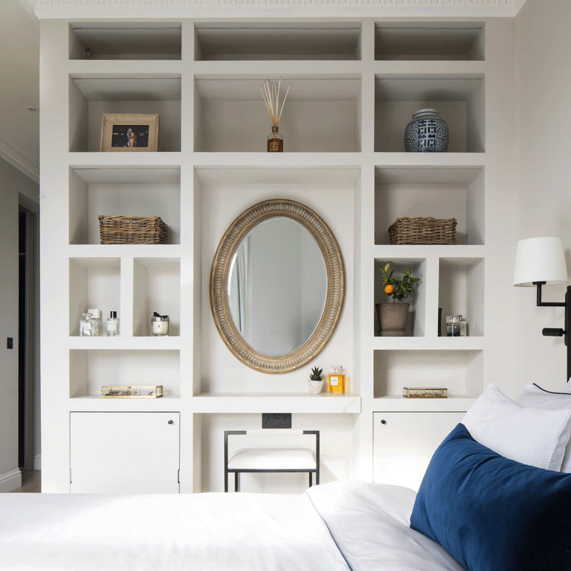 White bedroom with books and mirror