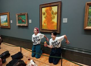 Campaigners in front of Van Gogh's Sunflowers after splashing it with soup