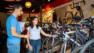 Woman looking at bike in store with a retail assistant