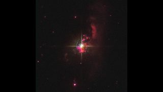 a bright cross of light with scatter red gasses around it in space.