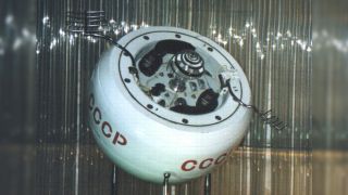 a circular white space probe with the red letters "CCCP" on its side is seen in a room