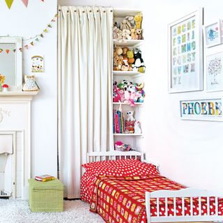 kids' bedroom with curtain behind bed concealing shelves of toys