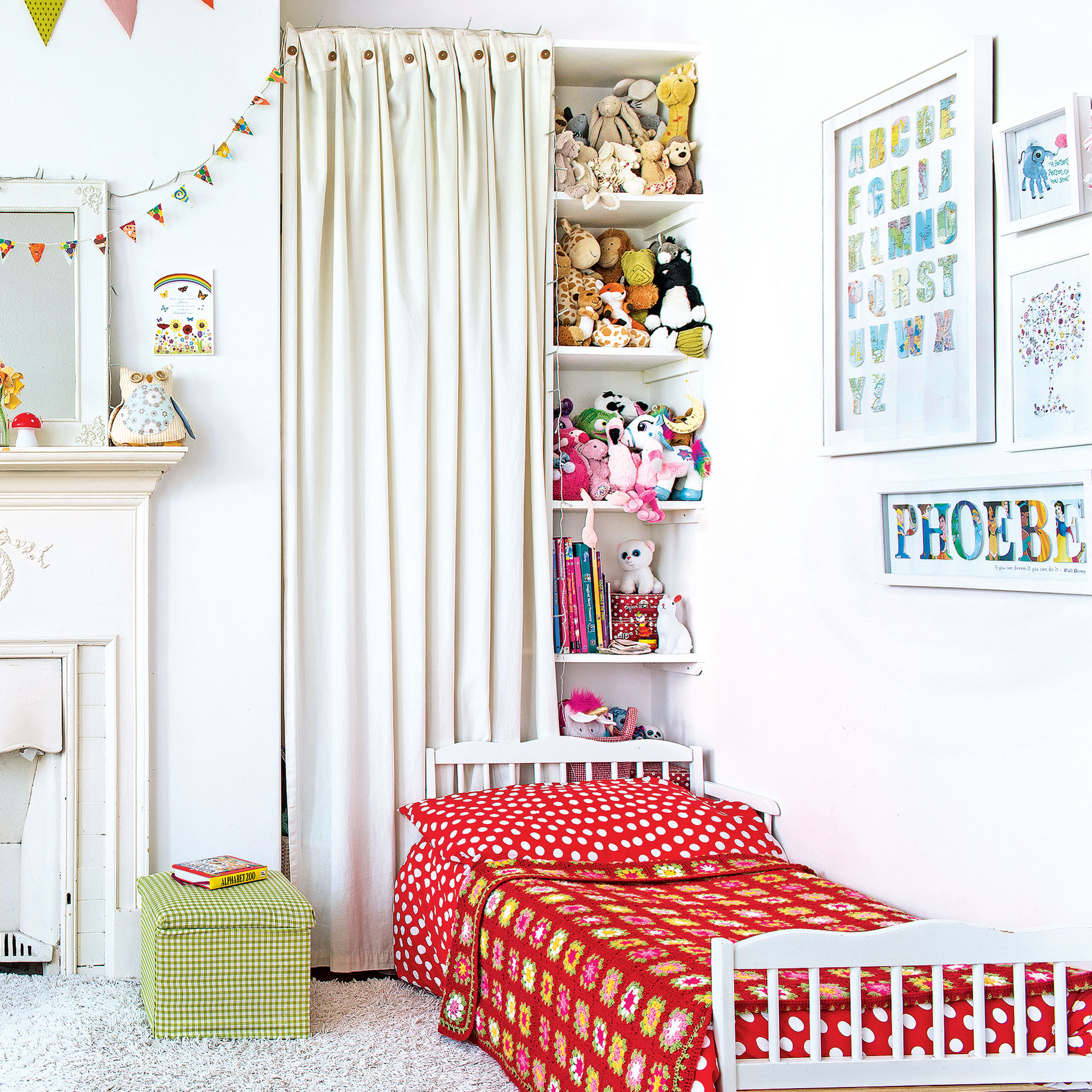 kids' bedroom with curtain behind bed concealing shelves of toys