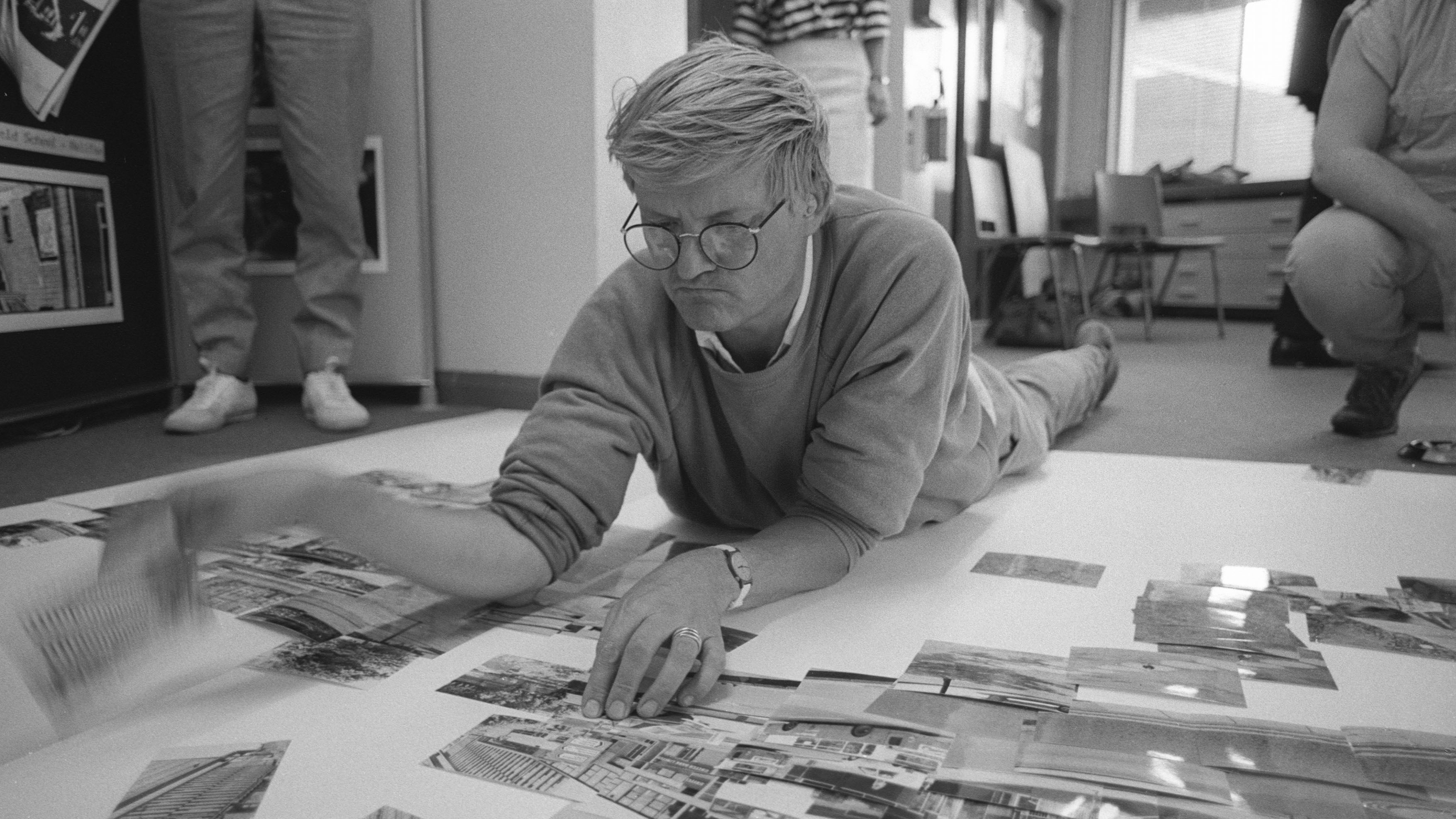 Black and white photo of the late David Hockney creating a 'joiner' photographic collage of the National Museum of Photography