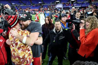 Travis Kelce #87 of the Kansas City Chiefs celebrates with his brother Jason Kelce as Taylor Swift looks on after a 17-10 victory against the Baltimore Ravens in the AFC Championship Game.