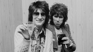 Ron Wood (left) of rock group Faces, and Keith Richards of the Rolling Stones (second from left), at a reception for producer Phil Spector, 4th October 1974