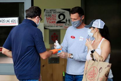 Hand sanitizer is distributed to customers outside Trader Joe's