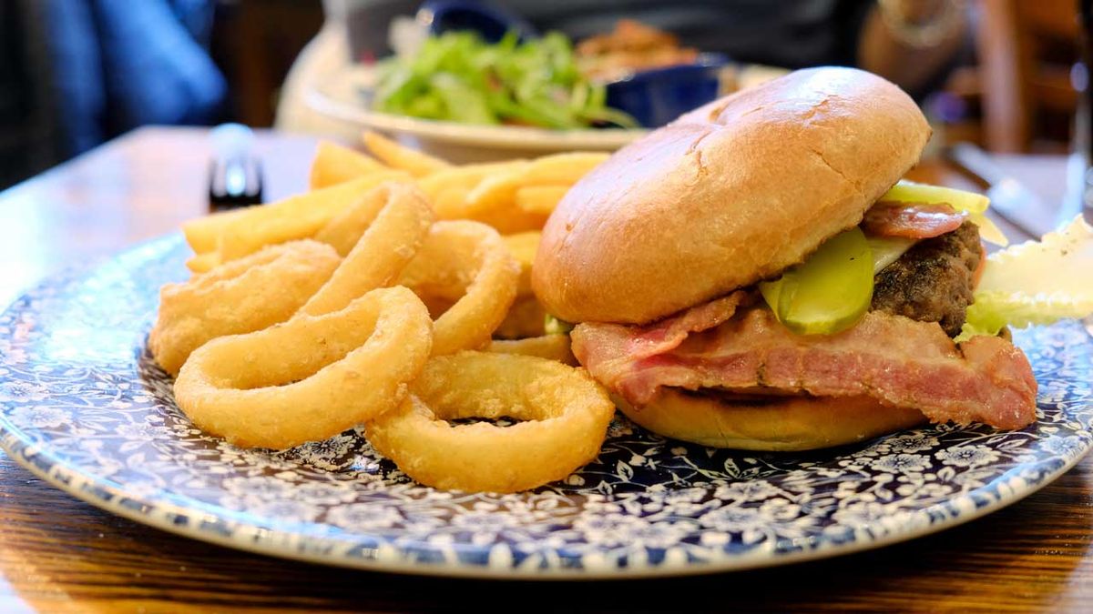 A JD Wetherspoons Ultimate Burger meal served with onion rings and chips.