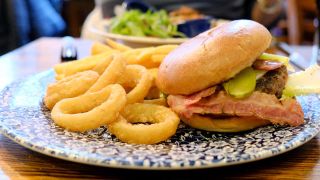 A JD Wetherspoons Ultimate Burger meal served with onion rings and chips.