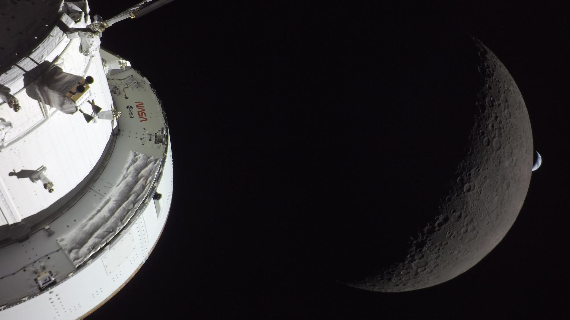 NASA&rsquo;s Orion spacecraft captures the Moon and the Earth in one frame during the Artemis II crew&rsquo;s deep space journey at 6:42 p.m. ET on the sixth day of the mission. The right side of NASA&rsquo;s Orion spacecraft is seen lit up by the Sun. A waxing crescent Moon is visible behind it. And then, a crescent Earth, tiny compared to the Moon, is about to set below the Moon&rsquo;s horizon on the right. 