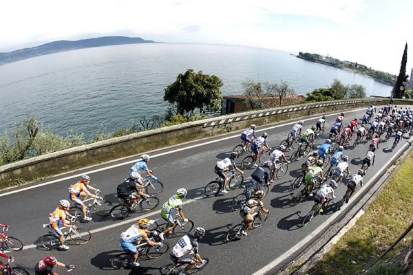 The Giro peloton rolls along the shore of Lake Garda.