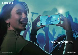 A lady taking a photo at a gig using the S23 Ultra