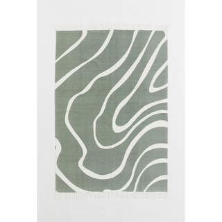 A green and white wave patterned cotton rug