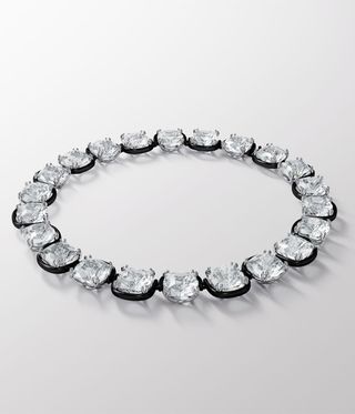 Crystal necklace edged with black against a pale grey background.