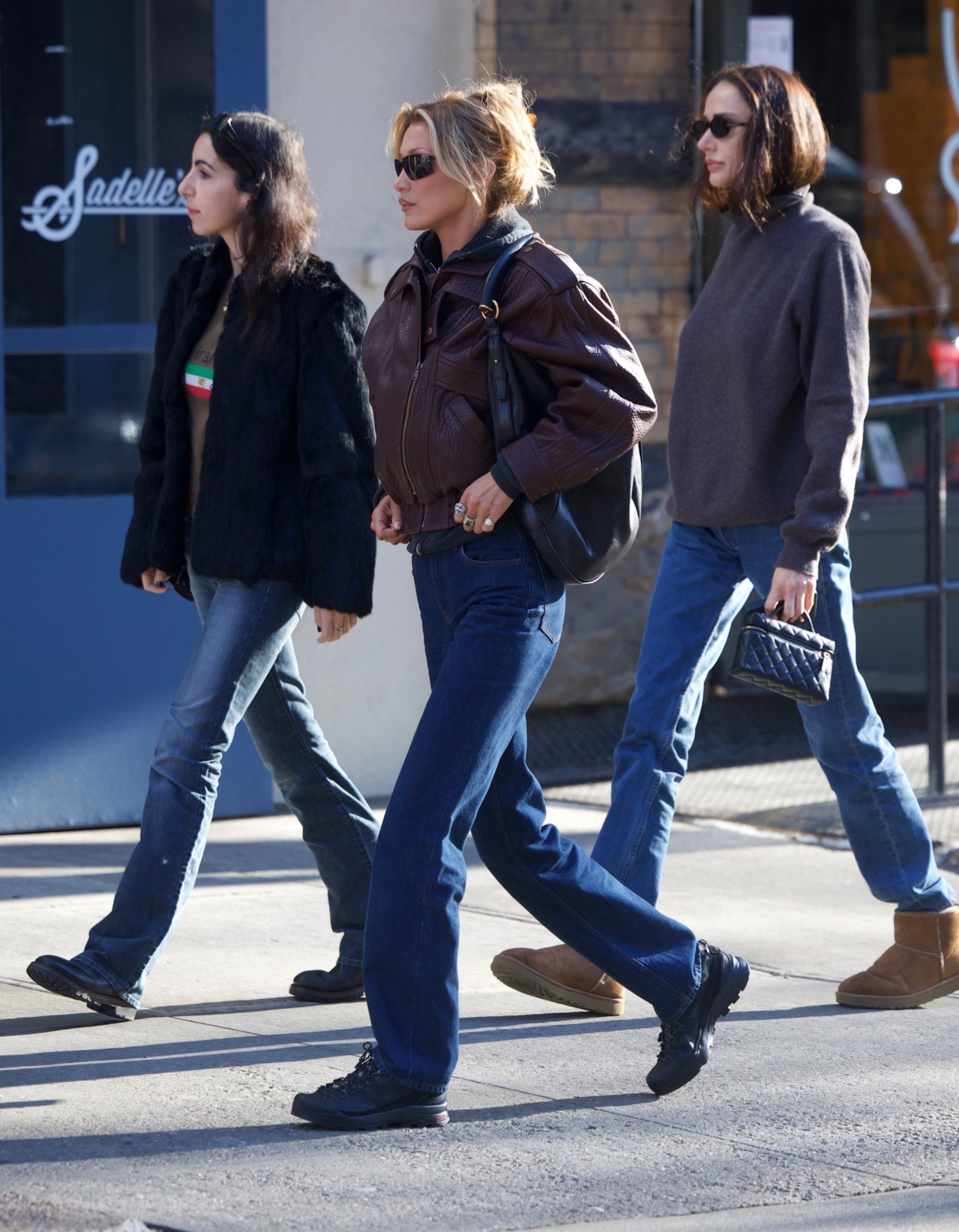 Bella Hadid wore a leather bomber jacket by Saint Laurent with dark wash jeans and Salomon sneakers