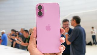 Pink Apple iPhone 16 held in the hand.