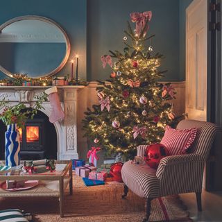 Christmas living room with tree with stripy bows and armchair.