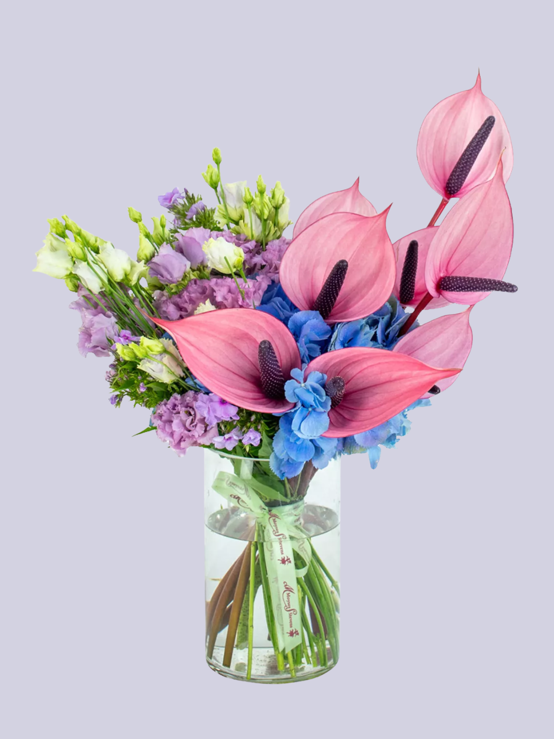 A glass vase with pink eustoma, anthuriums, hydrangeas, and phlox