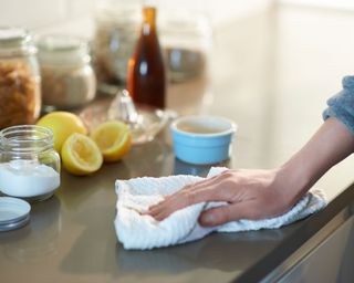 cleaning a kitchen work surface with a cloth