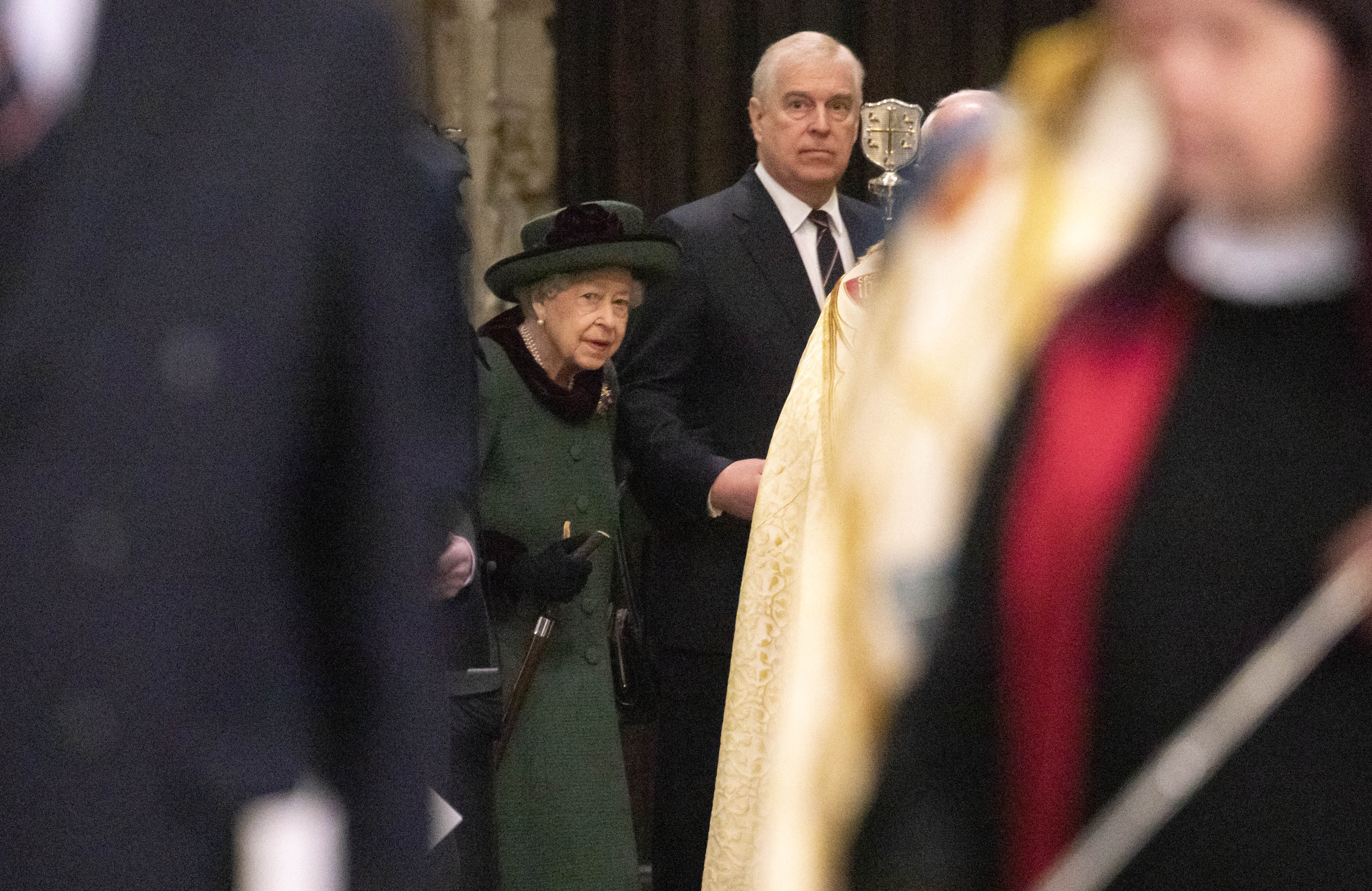 Queen Elizabeth wearing a green coat on the arm of ex-Prince Andrew at a service of Thanksgiving in 2022