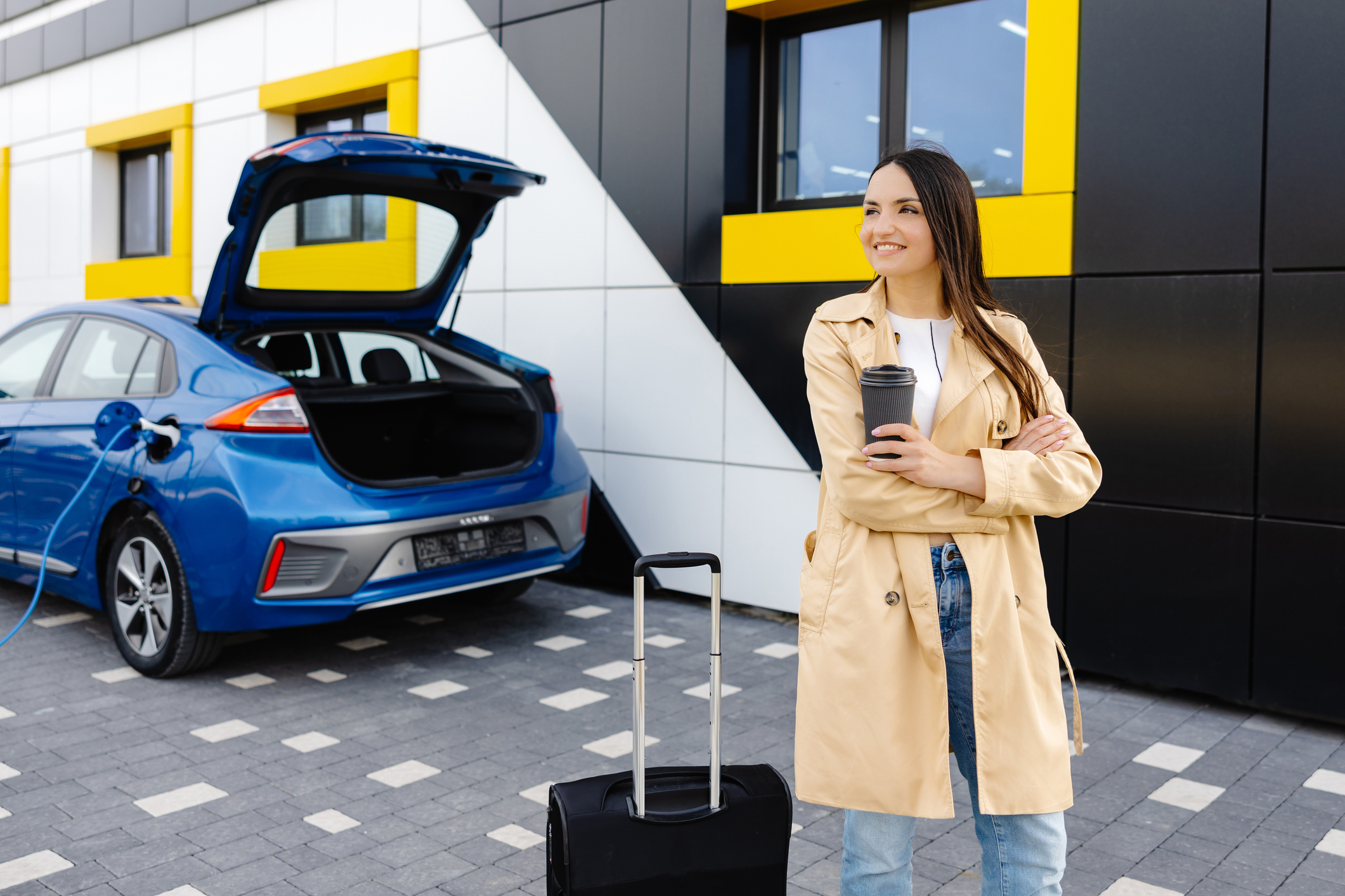 a woman waits as her EV charges