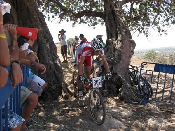 Marek Konwa (Poland) rides between some trees.