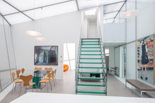 Glass staircase in angular white glazed living space