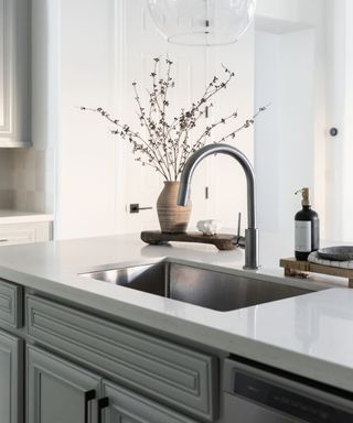 Kitchen with stainless steel sink under mounted in kitchen island, white