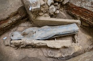 A photo looking down at a human-shaped lead sarcophagus in a burial beneath the Notre Dame floor.