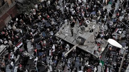 Peaceful protesters pray around an army tank near Tahrir Square, Cairo in 2011