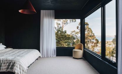 Bedroom featuring black-stained walls, white bedspread, and views over Hobart