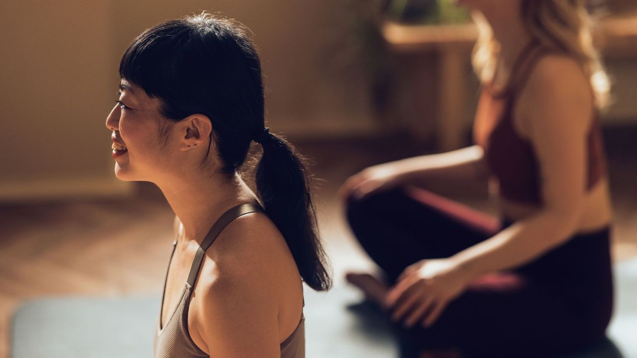 A woman trying mat Pilates in a studio with a friend