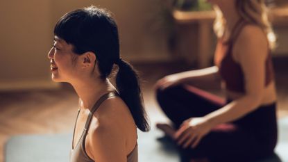 A woman trying mat Pilates in a studio with a friend