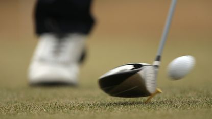 Close-up of a club hitting a ball off a tee