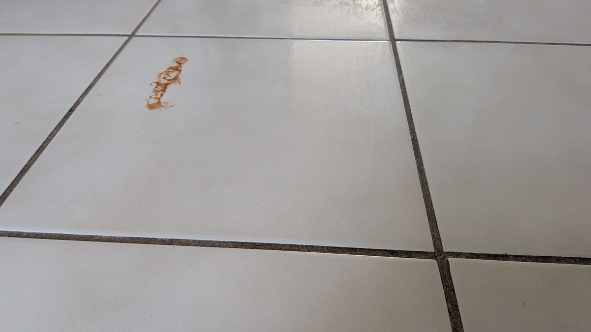 Remnant of ketchup on a tiled floor during the mopping test