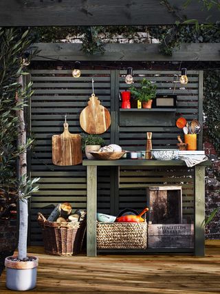 A outdoor decked surface with alfresco kitchen setup including cooking equipment and utensils