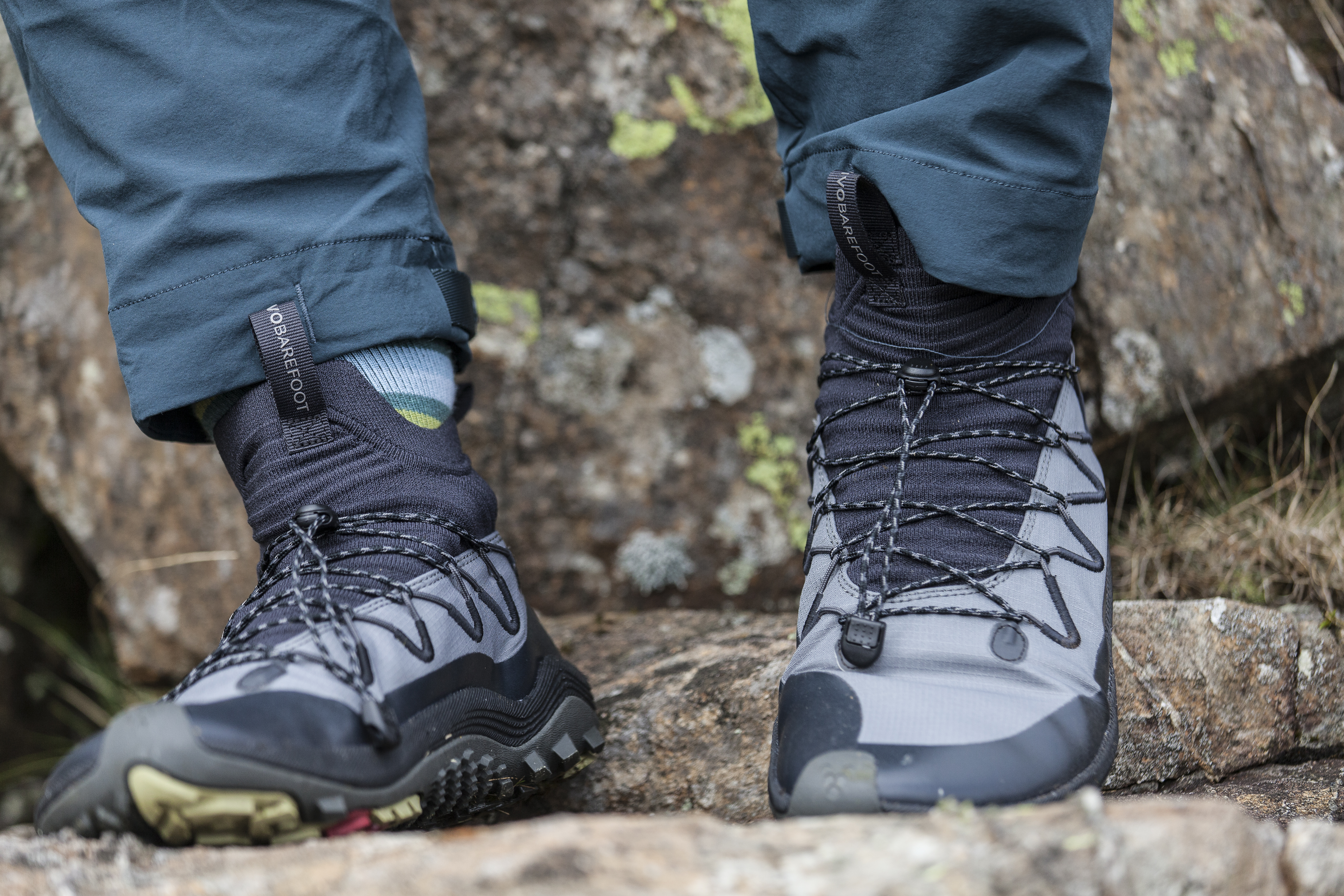 Woman wearing Vivobarefoot Primus Flow Mid hiking boots and scrambling in them