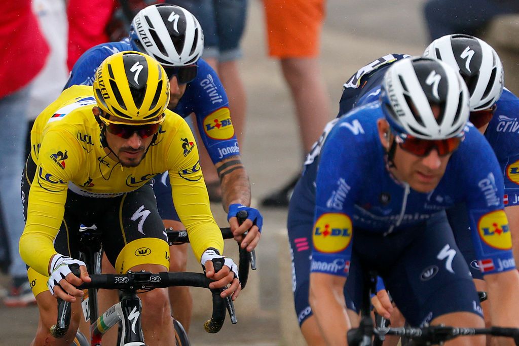 Team Deceuninck Quicksteps Julian Alaphilippe of France wearing the overall leaders yellow jersey L rides in the pack with his teammates during the 2nd stage of the 108th edition of the Tour de France cycling race 183 km between PerrosGuirrec and Mur de Bretagne Guerledan on June 27 2021 Photo by Thomas SAMSON AFP Photo by THOMAS SAMSONAFP via Getty Images