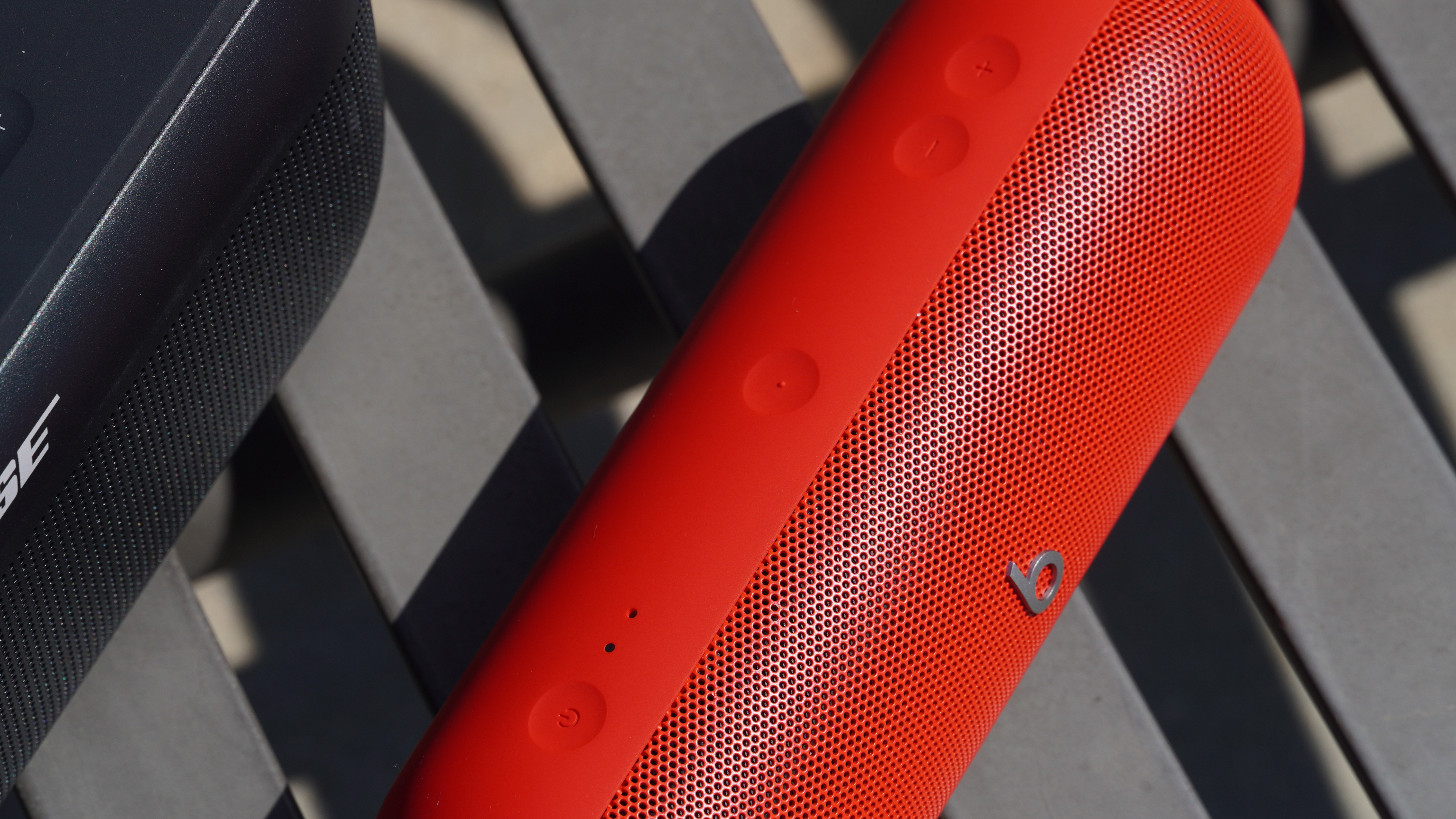 The controls on the Beats Pill (red) with the SoundLink Plus partly in the frame.
