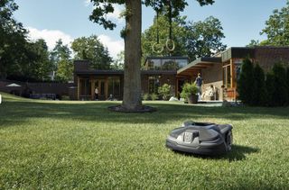 Husqvarna Automower 415X on grass in front of house