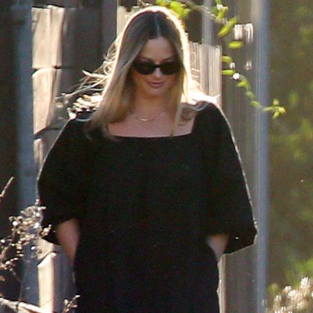 Margot Robbie walking in Los Angeles wearing a black puff sleeve dress