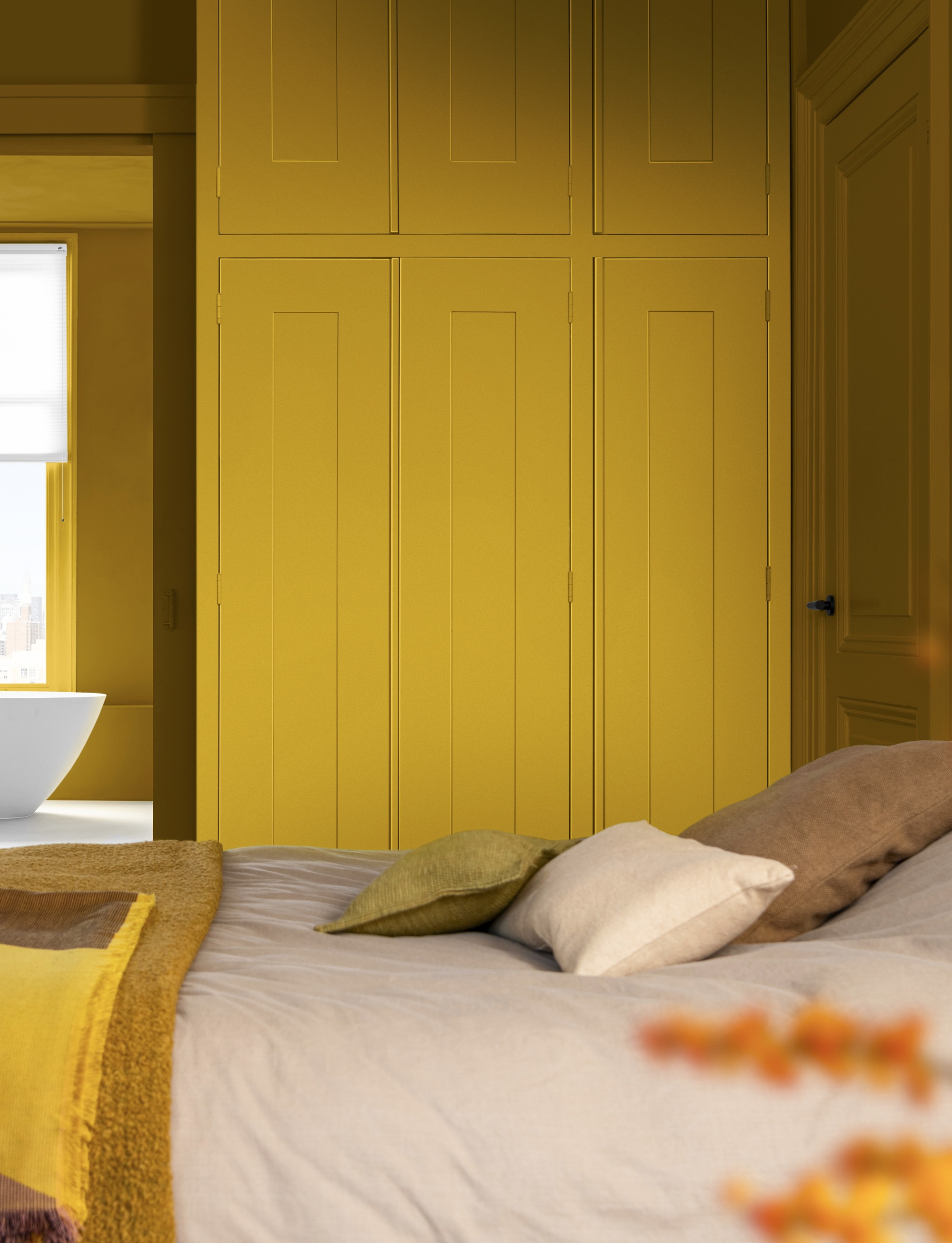 bedroom with yellow painted cabinets, yellow bedding, and beige sheets