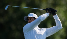 Aaron Rai hits an iron shot and watches it in the air